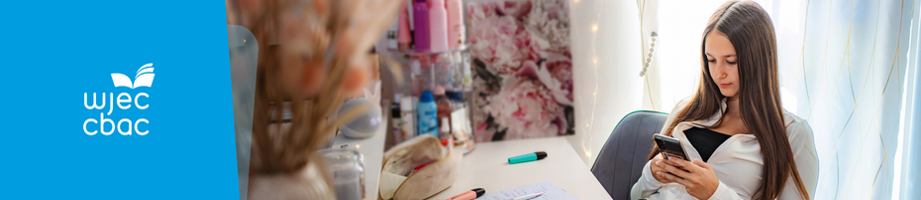 Learner are desk with study materials and on her phone.