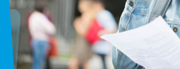 Close up of a learner holding a results paper.