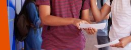 Close-up of two learners holding their results paper.