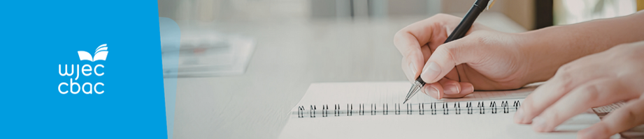 Close-up of hands writing in a notebook.